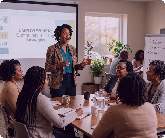 A black woman speaking or presenting to a small group of black women